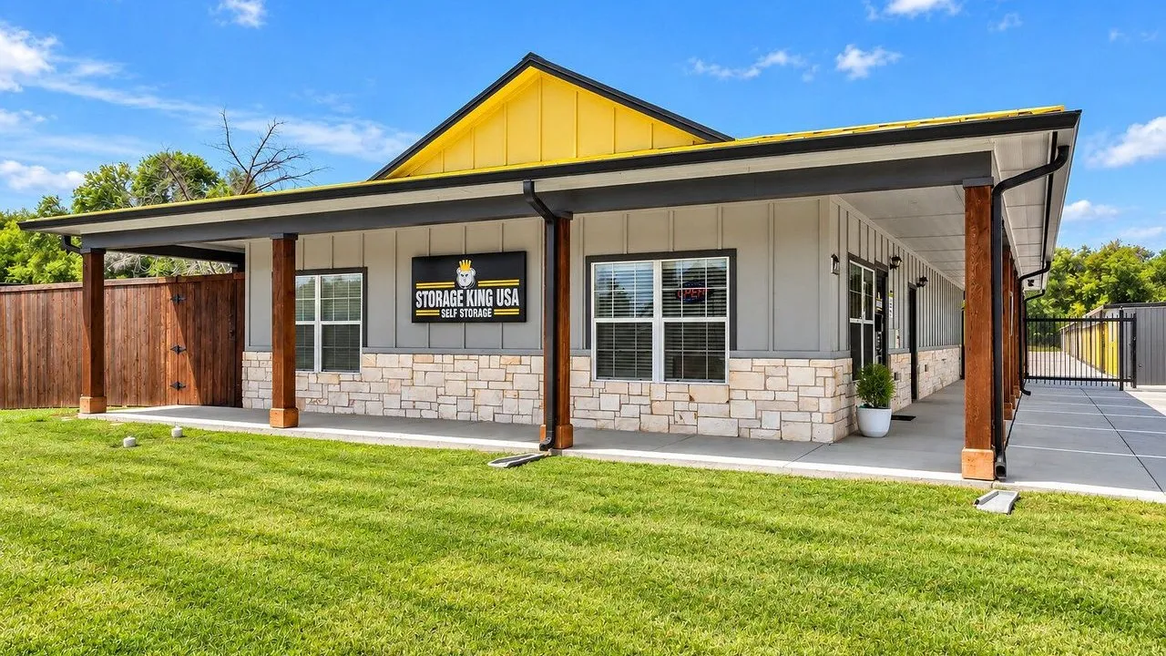 Storage King USA self-storage office building with yellow roof trim and a lawn.