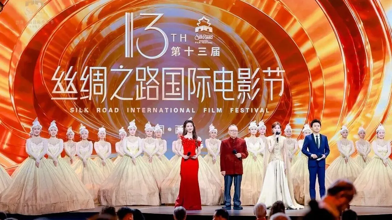 Presenters and dancers onstage before a Silk Road International Film Festival backdrop.
