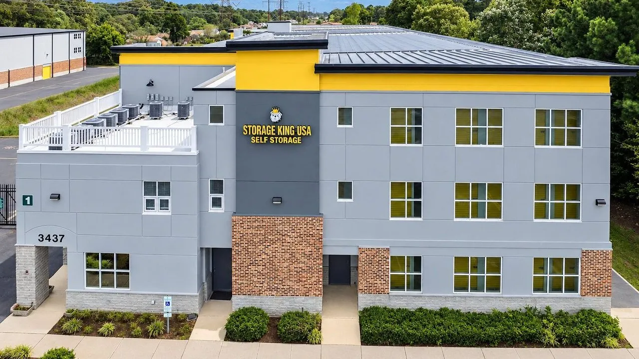 Storage King USA self-storage building with gray walls, yellow trim, and brick accents