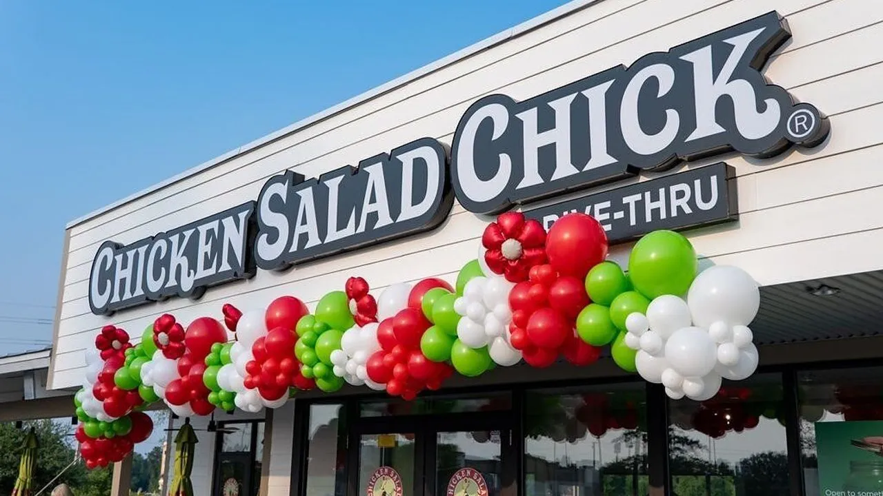 Chicken Salad Chick storefront decorated with red, green and white balloon garlands.