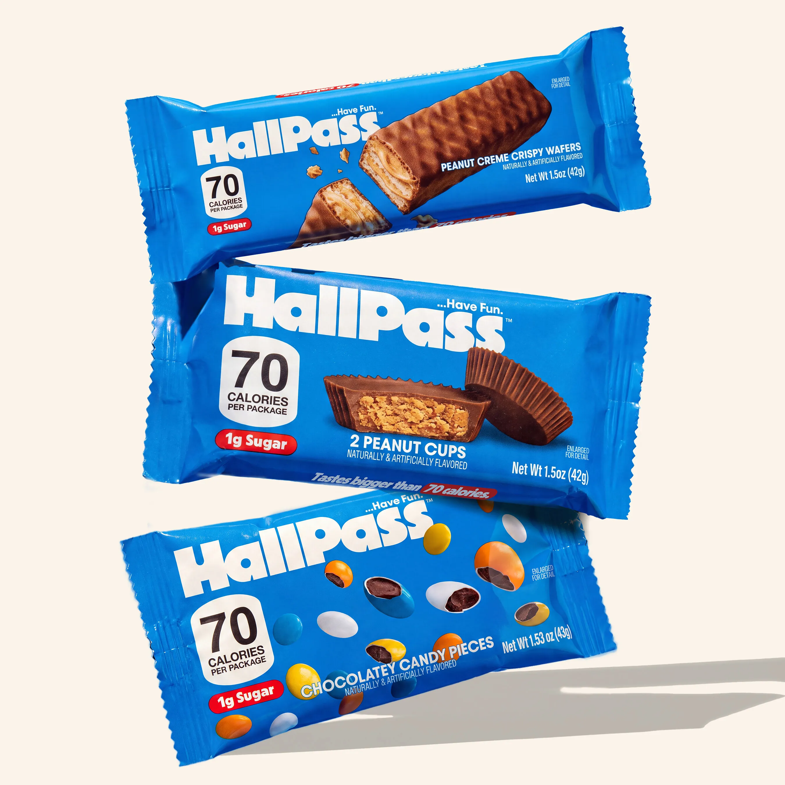 Three blue HallPass snack packages, including peanut cups and candy-coated chocolate varieties.