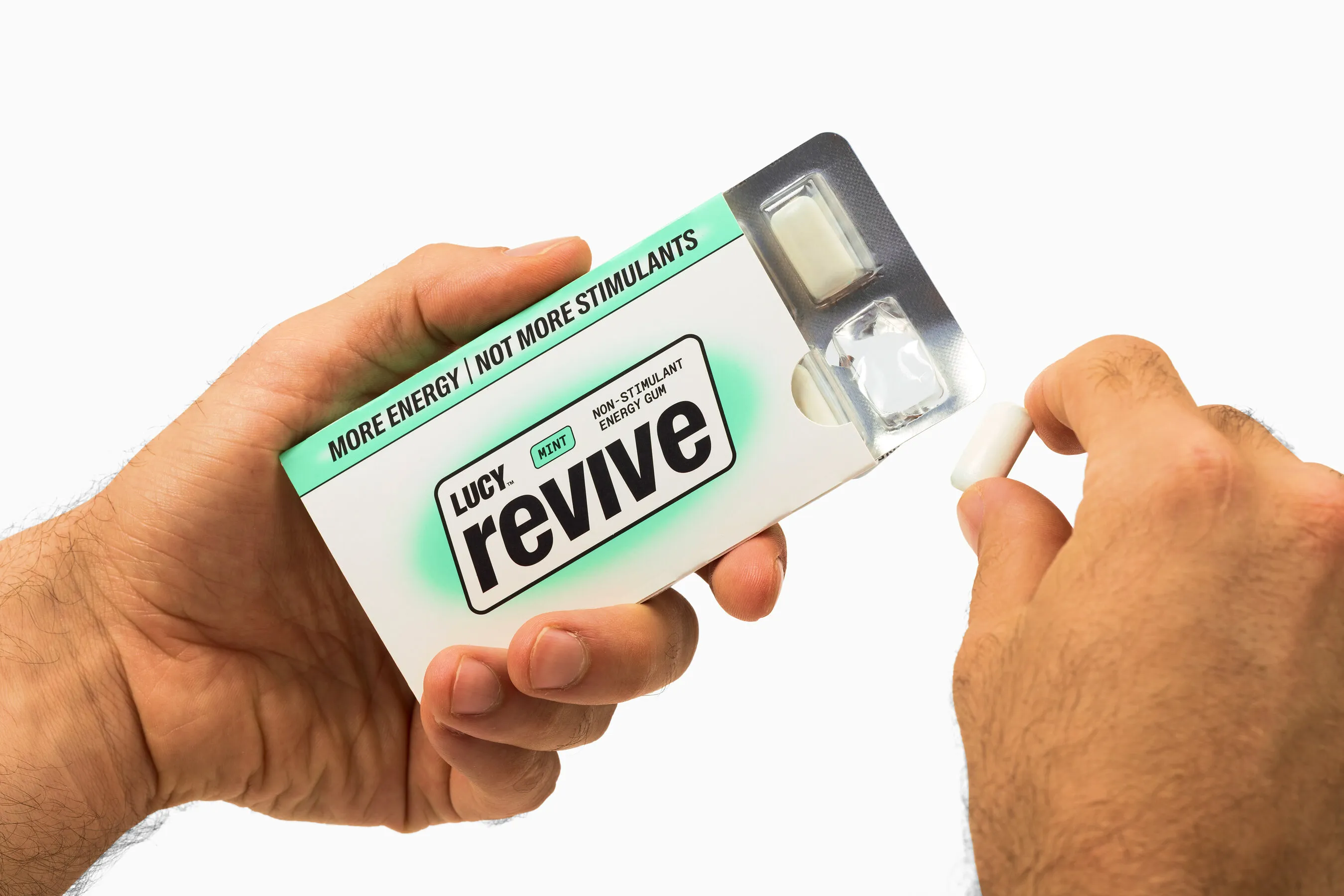Hands holding a pack of Lucky revive mint energy gum and removing a piece of gum