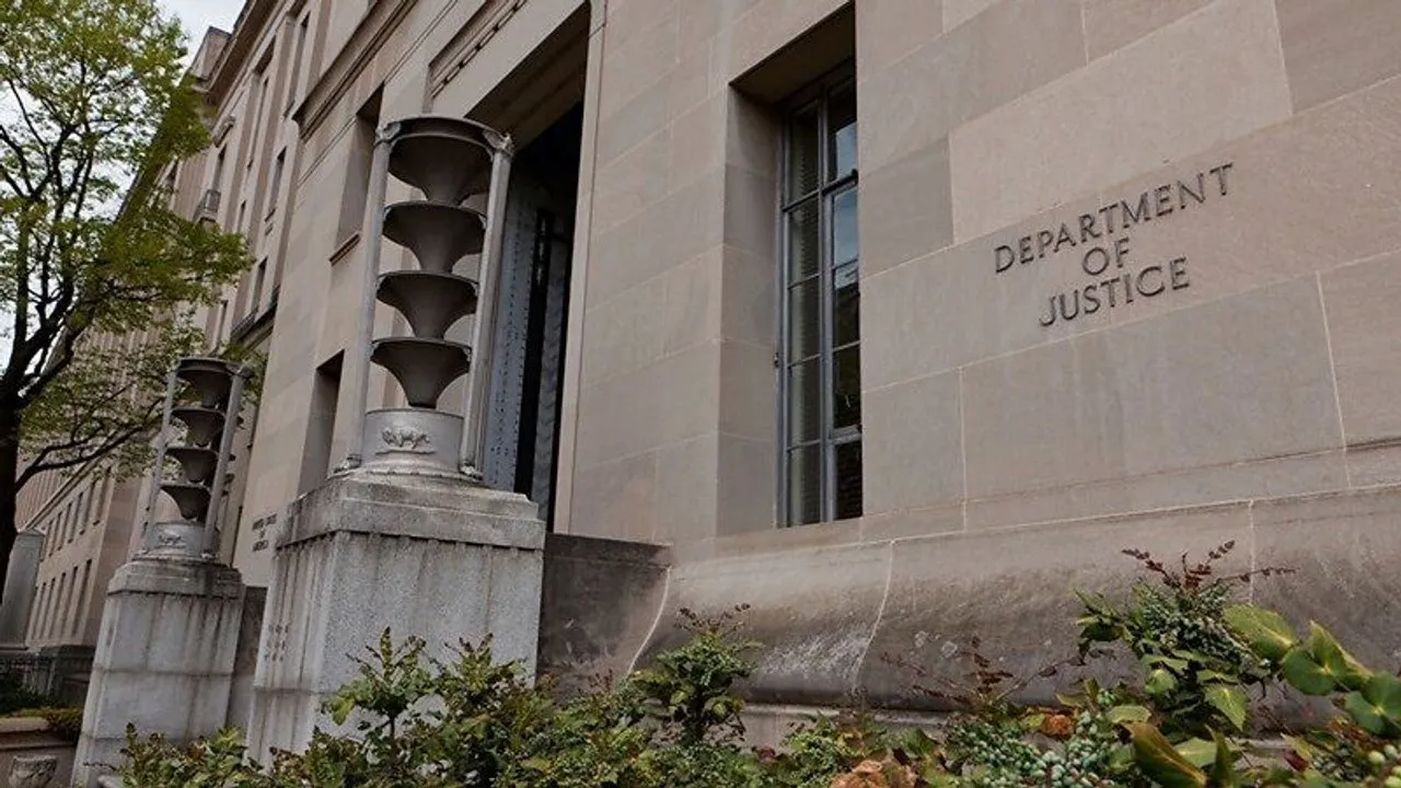Exterior of the U.S. Department of Justice building with its name engraved on a stone wall.