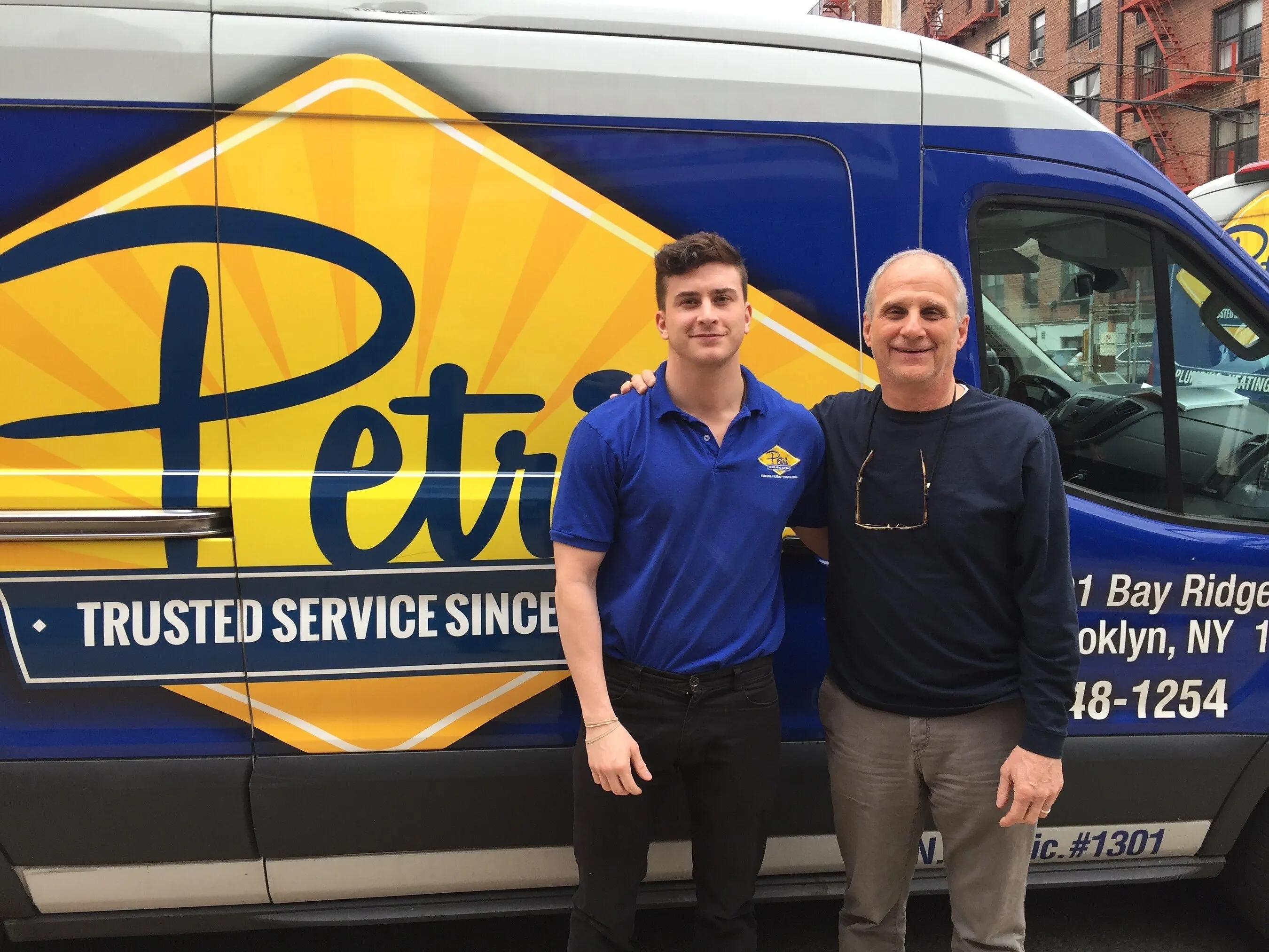 Chris Petri and Michael Petri standing beside a Petri Plumbing and Heating van.