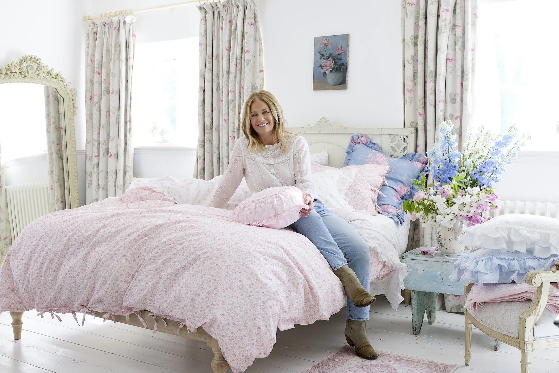 Pink floral duvet cover set on a bed with matching curtains, pillows and ruffled bedding.