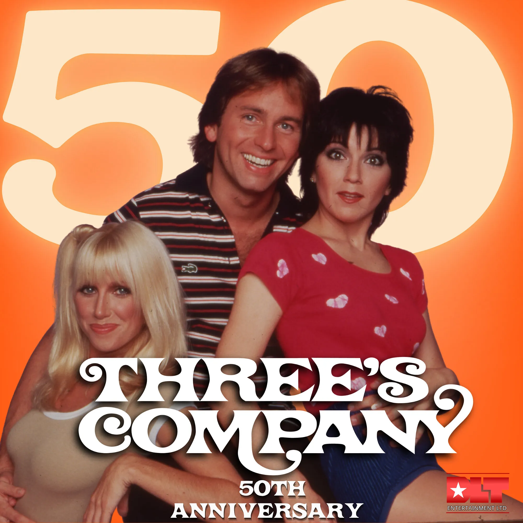 Three people posed in front of an orange Three’s Company 50th anniversary logo.