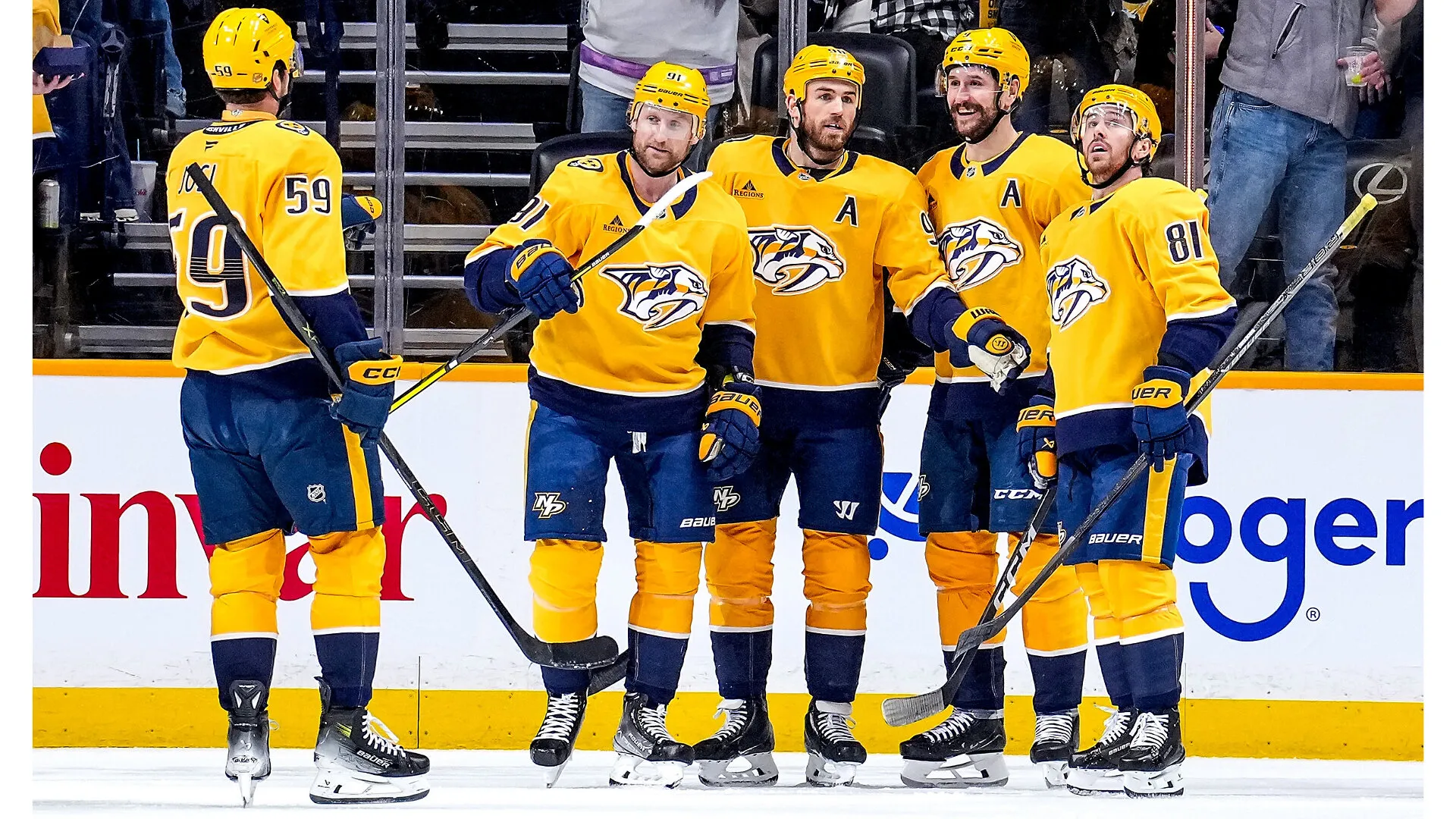 Five Nashville Predators hockey players in yellow uniforms stand together on the ice.