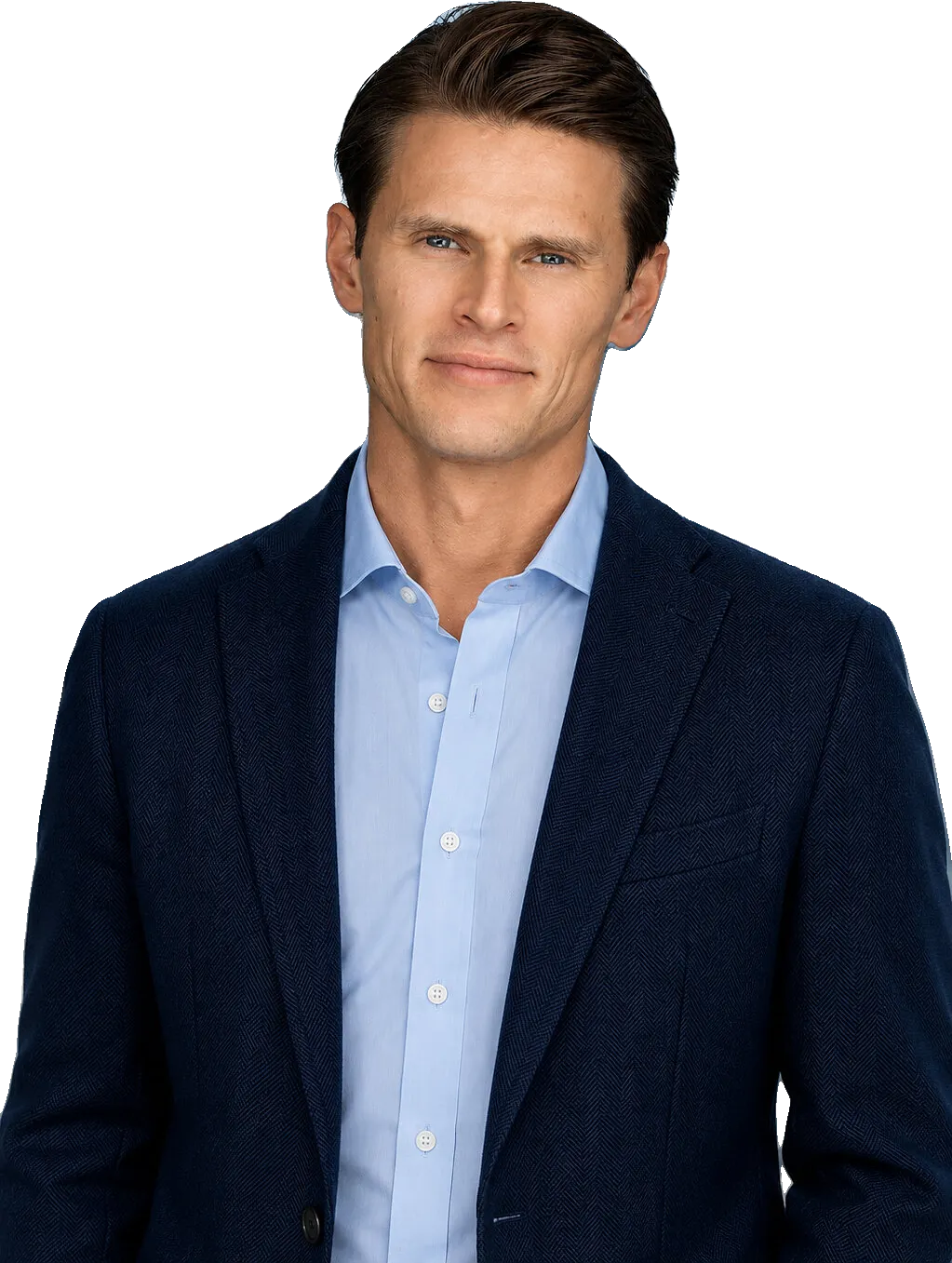Man in a navy blazer and light blue shirt standing before a city skyline.