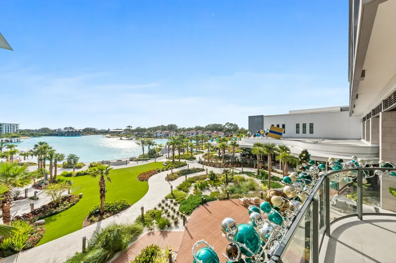Balcony overlooking a landscaped lakeside resort courtyard decorated with teal, gold and silver balloons