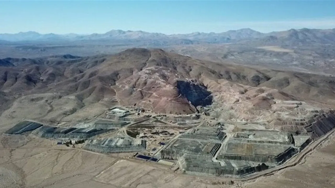 A sprawling excavation site with terraced structures in a barren mountain valley.